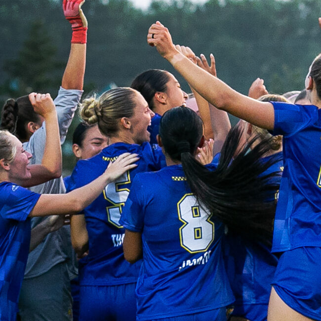 group of sdsu women's soccer players celebrating in a huddle