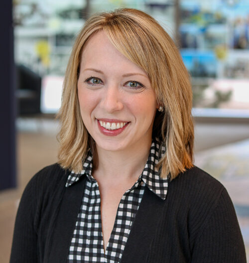 Professional headshot of Maggie Miller with a blurred background.