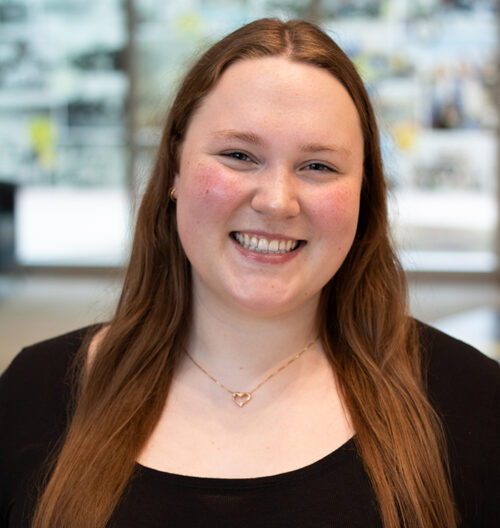 Headshot of Allison Fesler smiling at the camera with a blurred background.