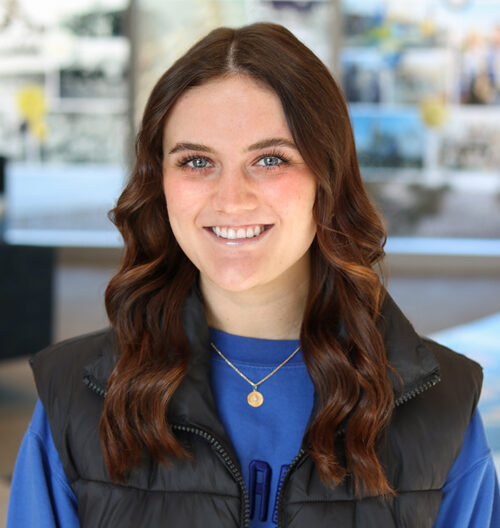 Professional headshot of Gracie Barber with a colorful, blurred background