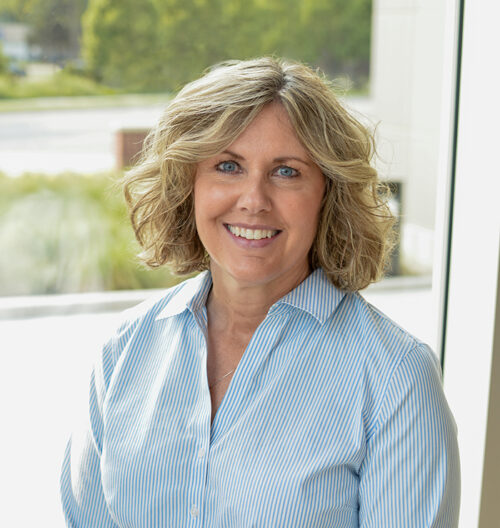 Professional headshot of Jill Hoflock, with blurred green background.