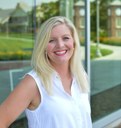 Professional headshot of Keli Books, with a blurred landscape background.