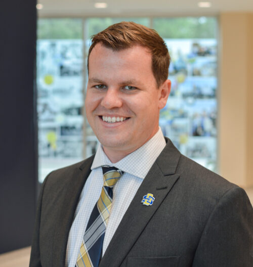 Professional headshot of Mark Sandager, with a blurred background.