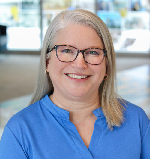 Headshot of Pam Olson with a blurred, colorful background
