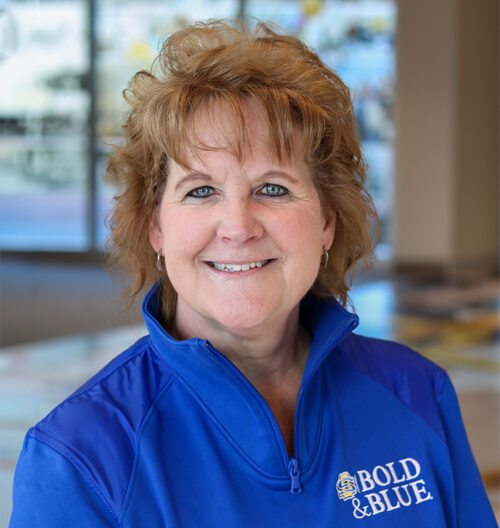Professional headshot of Sondra Patrick, with a blurred colorful background.