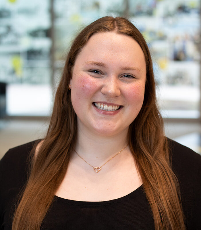 Headshot of Allison Fesler smiling at the camera with a blurred background.