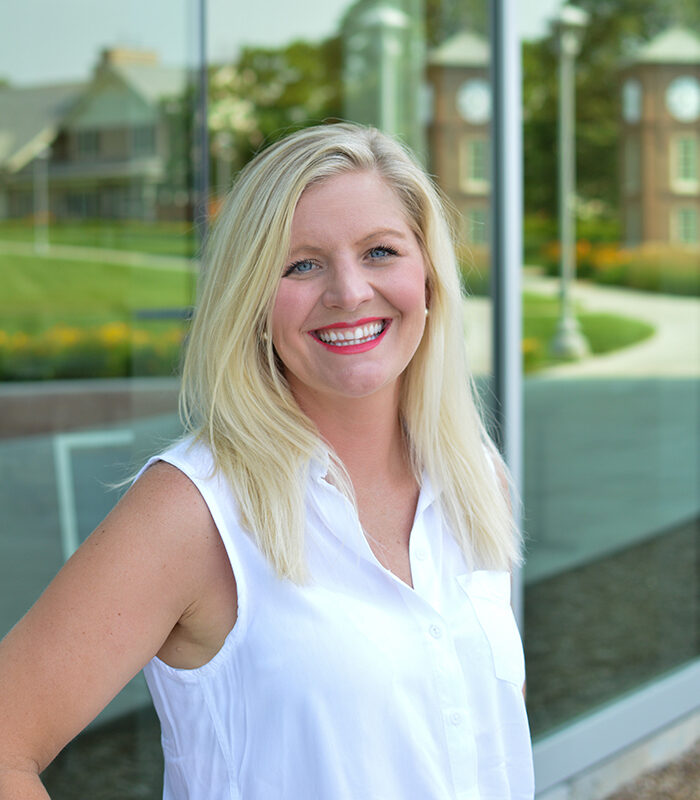 Professional headshot of Keli Books, with a blurred landscape background.