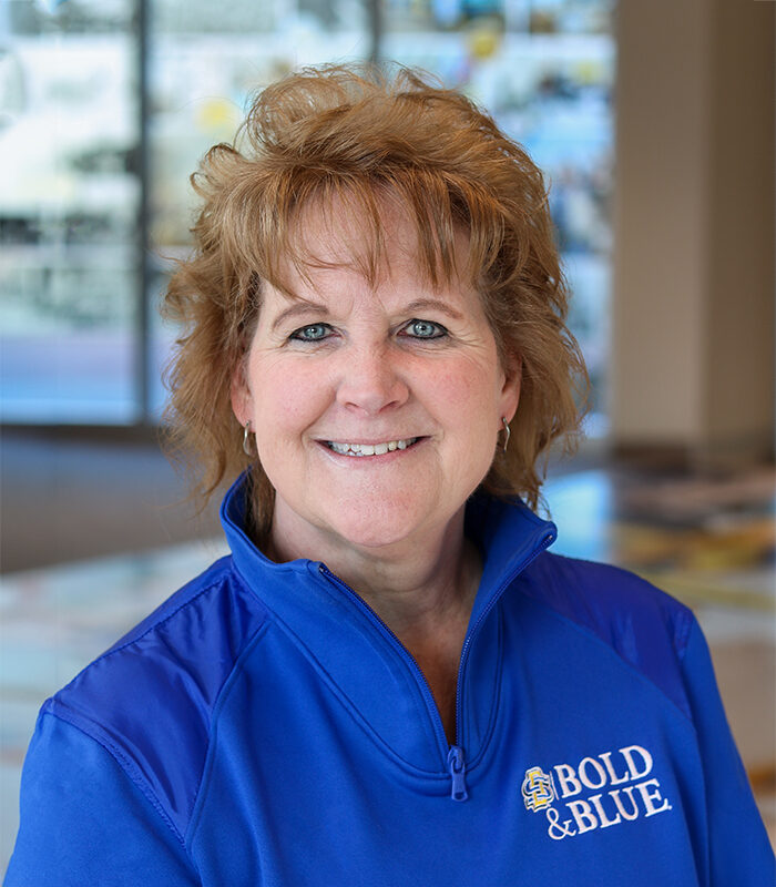 Professional headshot of Sondra Patrick, with a blurred colorful background.