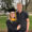 Sydney and Nathan Adrian smile for the camera. Syndey is wearing a cap and gown for graduation and Nathan has his arm around her.