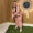 Allison Fesler smiles while holding a golf club, putting.