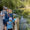 Carolyn Poss with her husband and two kid on a small bridge with a stream and greenery in the background