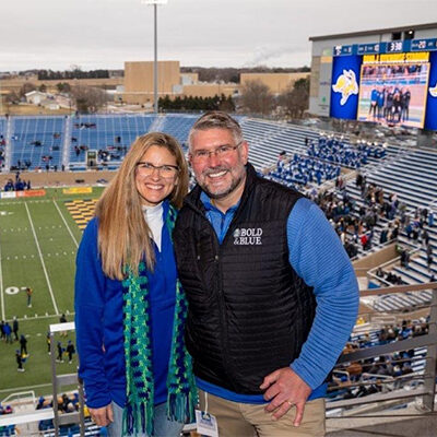 Mike Birgen and his wife, Tina, with the Dana J Dykhouse Stadium in the background