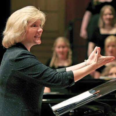 Dr, Diddle smiles as she directs the choir.
