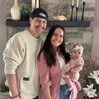 Emily Punt smiles with her husband and baby daughter
