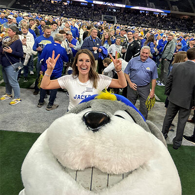 Jenn McCloud smiles with Jack the Jackrabbit mascot