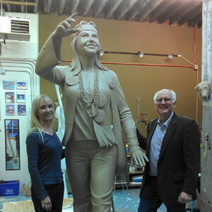 Lonnie Humphries and David Anderson stand with the casted sculpture of Dirty Lil in a workshop.