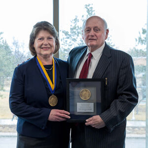 Dr. Eluned Jones and Larry Ness stand with their investiture medallions.