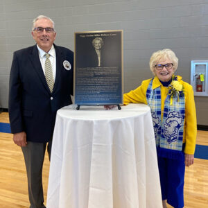 President Barry Dunn and President Emerita Peggy Gordon Miller smile while standing next to the plaque that will be displayed in the Wellness Center in honor of Dr. Miller.