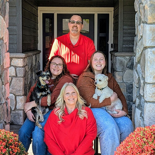Allison Fesler smiles with her family on a beautiful porch.