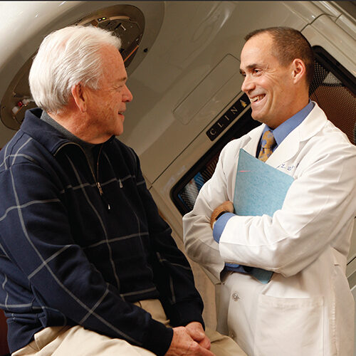 Dick Deming and a patient smiling at one another