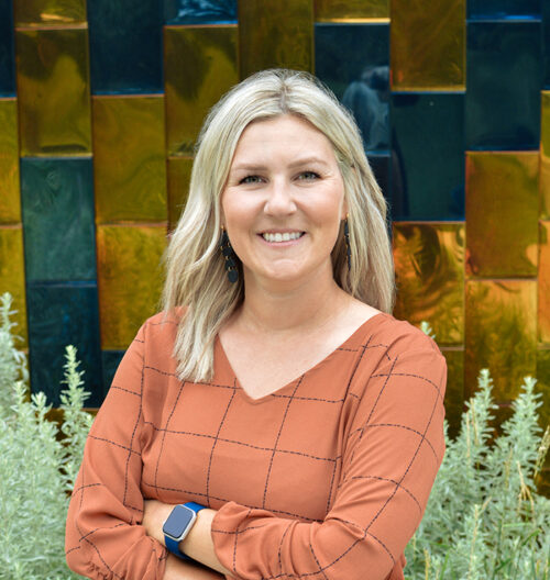 Professional headshot of Amanda Nelson, with a blue and gold background.