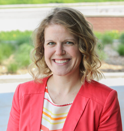 Professional headshot of Erin Glidden, with a blurred background.