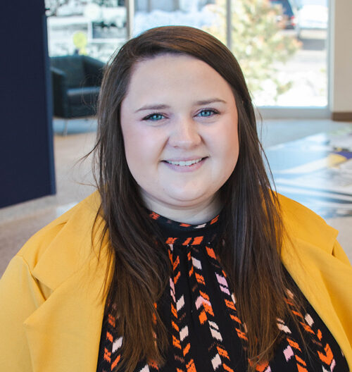 Professional headshot of Samantha Nogelmeier with a colorful blurred background.