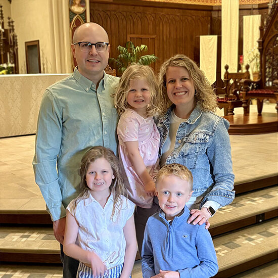 Erin Glidden and her husband Tyler smile with their three kids