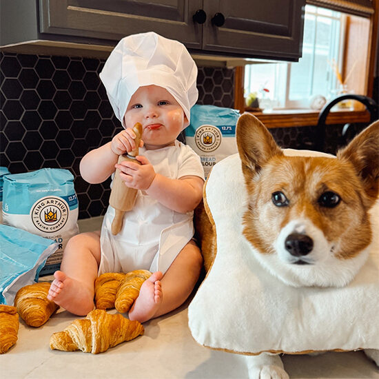 Trish's son and dog smile in their cute Halloween costumes - her son as a little baker and her dog as a piece of bread