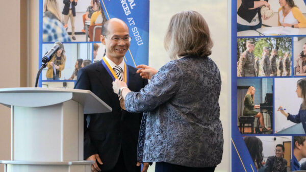 Dr. Zhiguang (Gerald) Wang receiving his medallion, smiling ear to ear.
