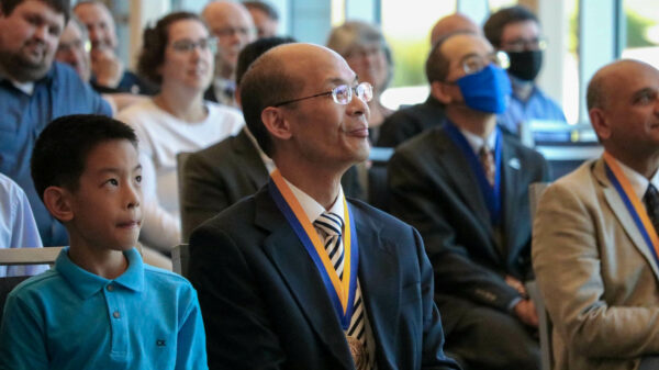 Dr. Wang sitting with son, Max, in the crowd.