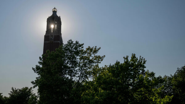 Campanile photo with the sun peeking through the windows at the very top of the monument.