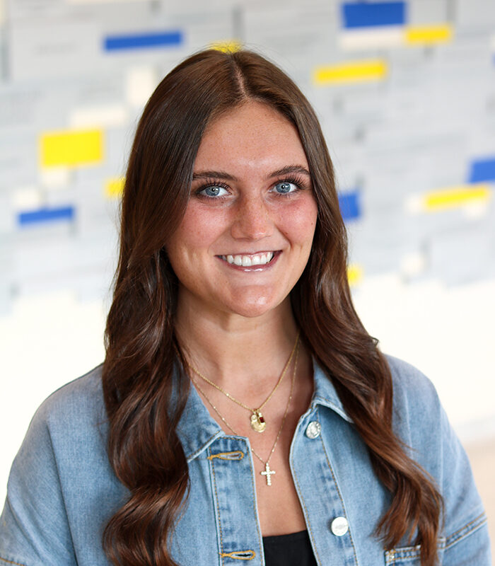 Professional headshot of Gracie Barber with a colorful, blurred background