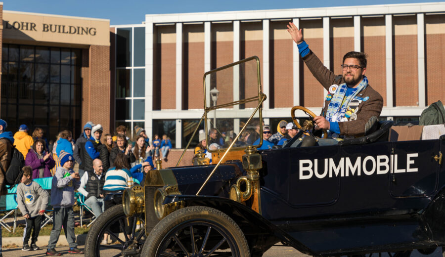 2022 Grand Pooba, Regen Wiederrich, waves to the crowd while driving the Bummobile during the parade